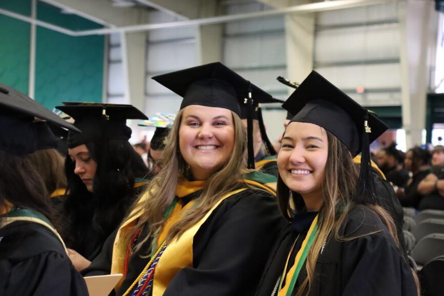 两个微笑的学生在毕业典礼上